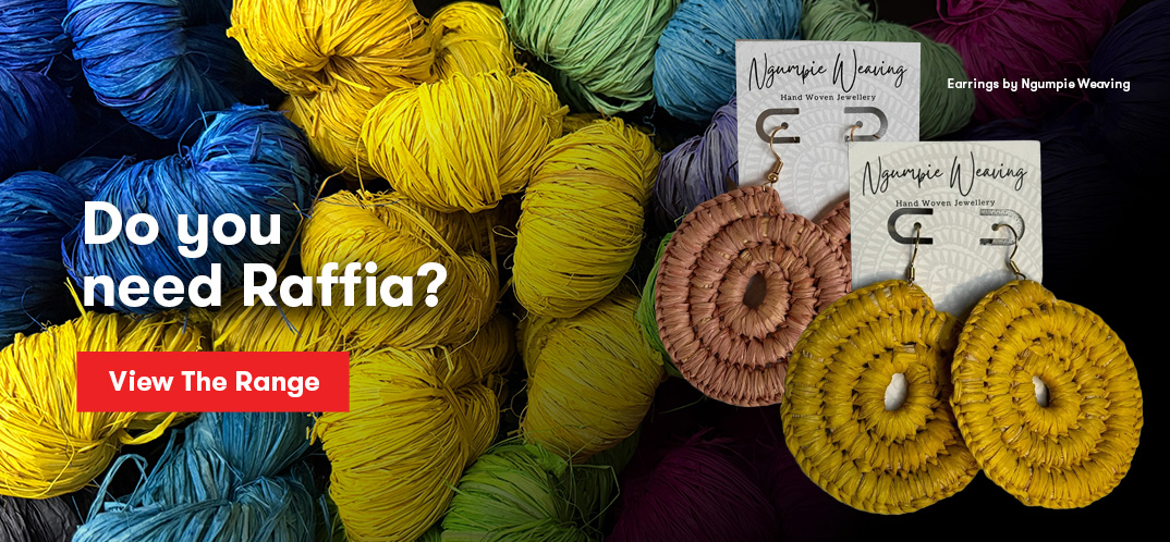 Raffia earring made by Ngumpie appearing next to balls of raffia